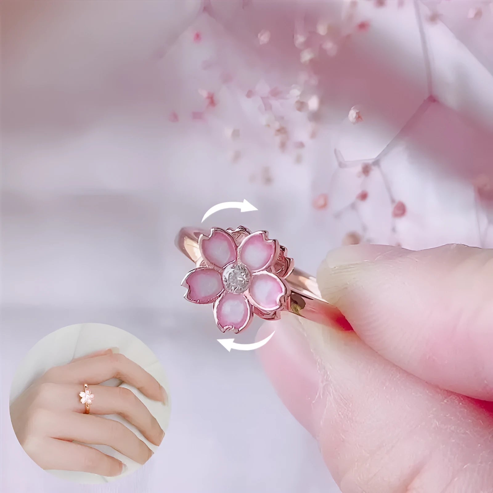 Cherry blossom rotatable ring with rose gold finish, adjustable opening, and silver base shown on a finger
