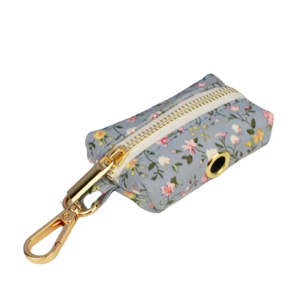 Blue floral patterned dog collar set with leash, bow tie, vest, and poop bag on a white background