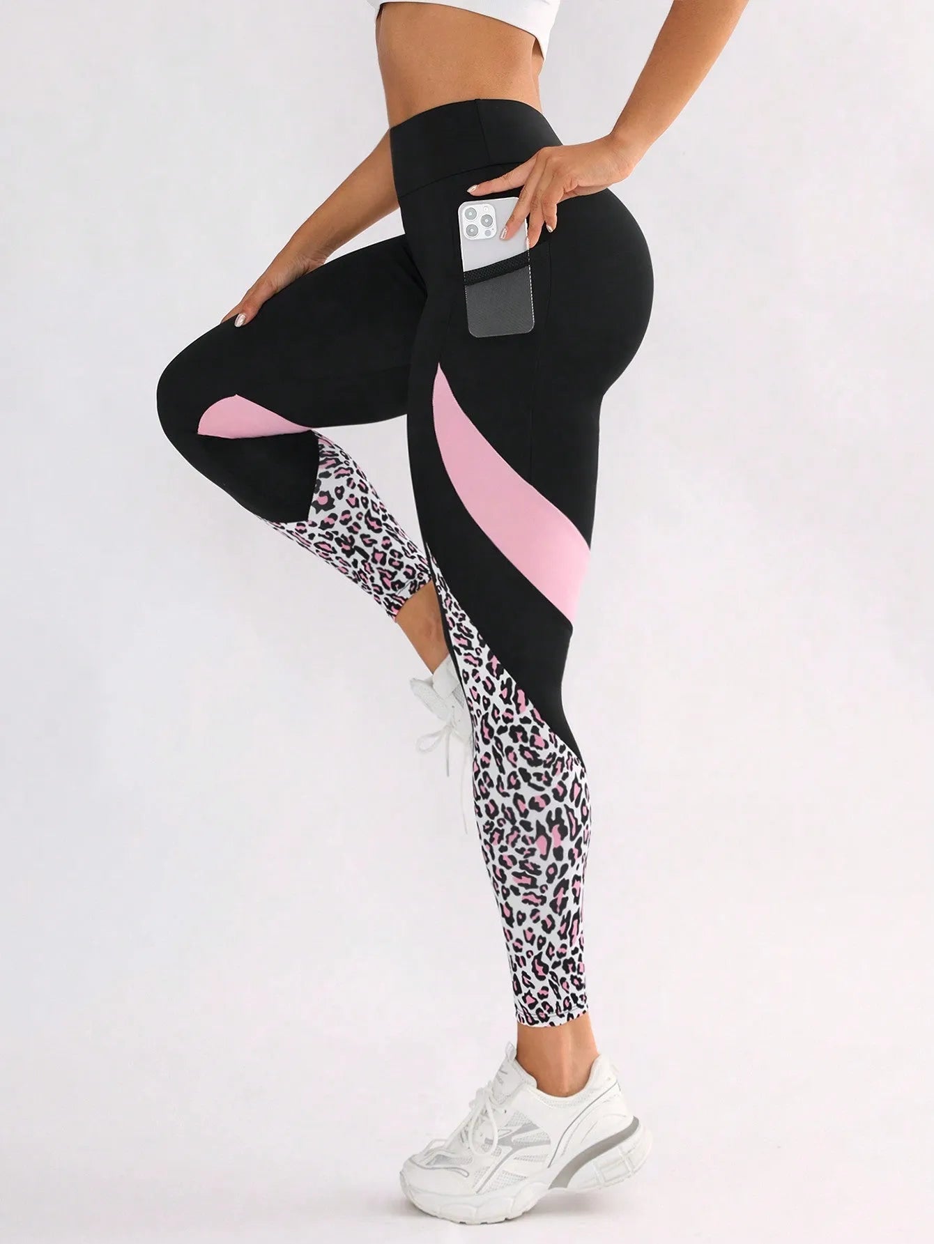 Black women's high-waisted yoga leggings with contrast patchwork design and side pocket.