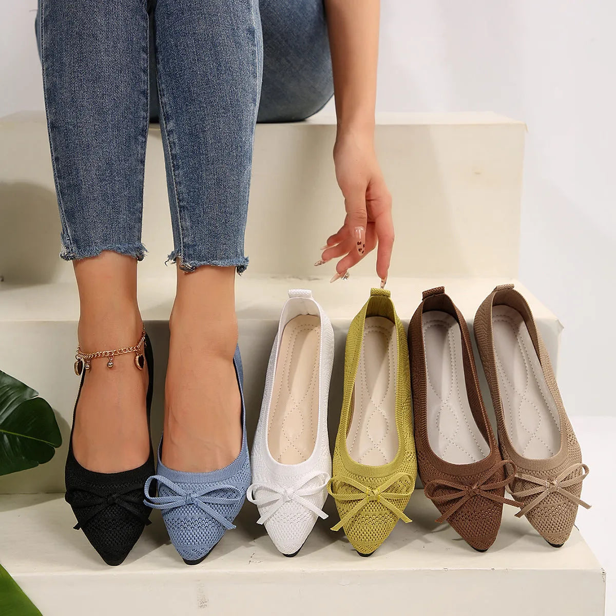 Women's blue knitted flat loafer with bow detail on pointed toe, showing rubber sole