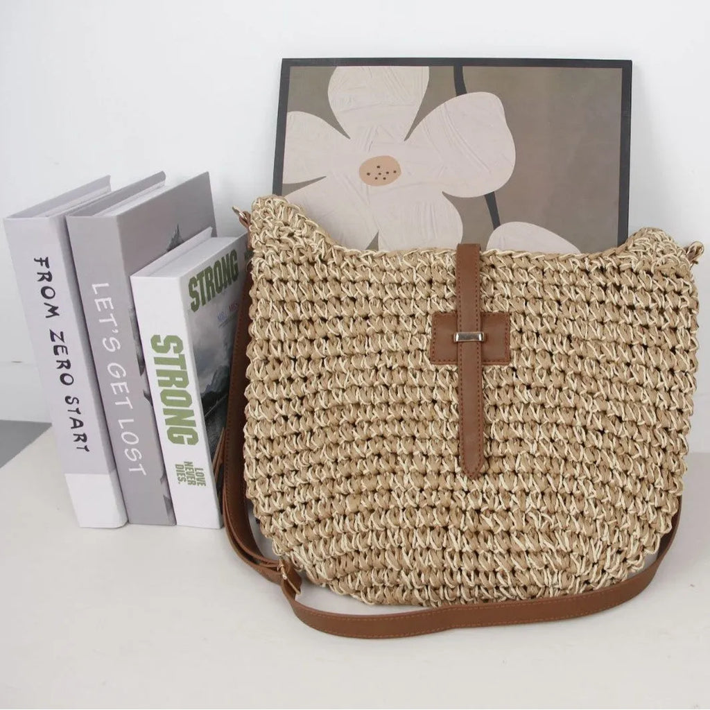 Handmade beige square woven bag with a shoulder strap on a neutral background.