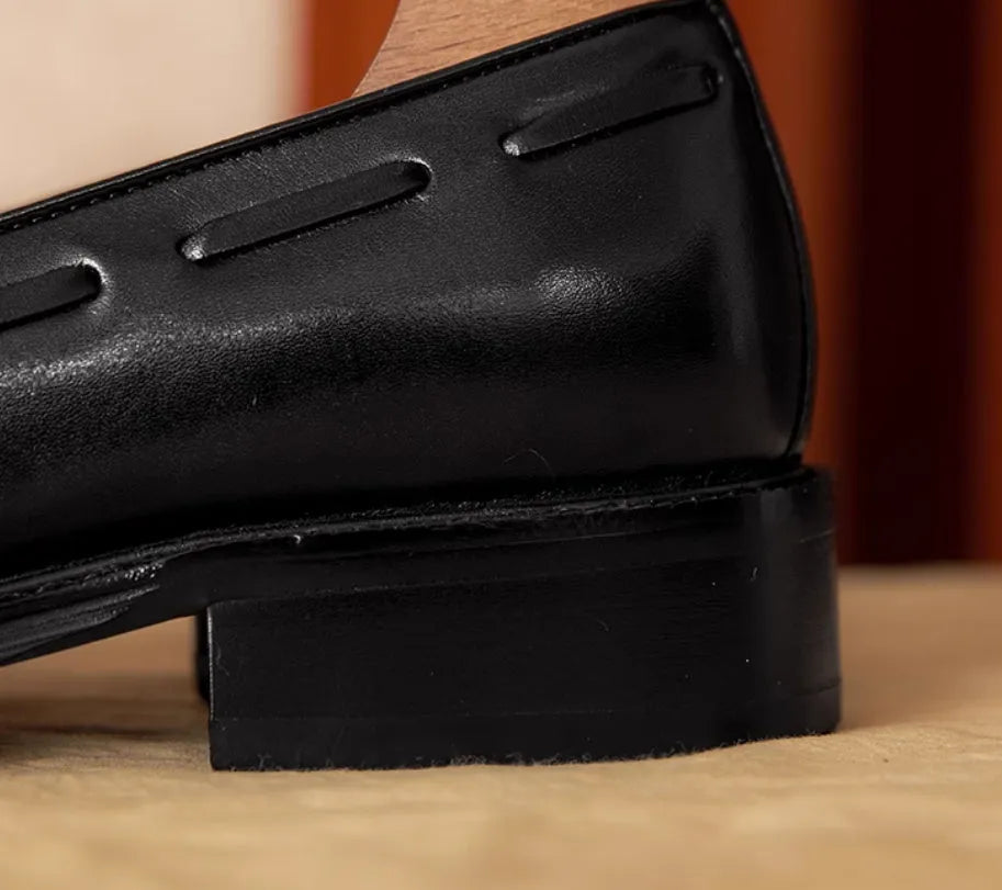 Men's black genuine leather loafers with a fringed detail and slip-on design.