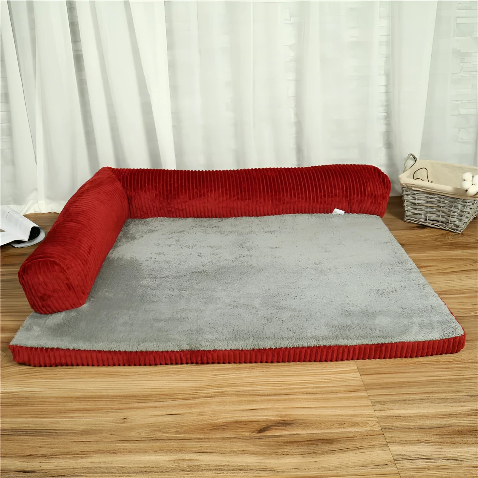 Corduroy dog sofa bed with bolster sides on a wooden floor, showing grey colour option in large size.