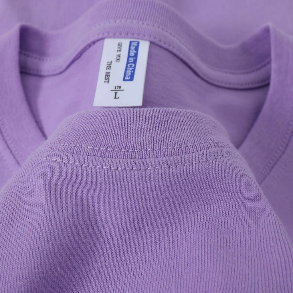 A loose-fit, thick cotton T-shirt in a solid colour, shown on a hanger.