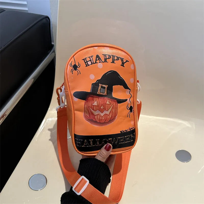 Black Halloween crossbody bag with orange pumpkin, white ghost, and bat graffiti print, shown on a model.