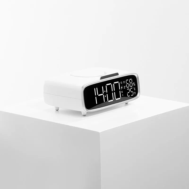 White wireless charger bluetooth speaker with LED night light and alarm clock display on flat surface