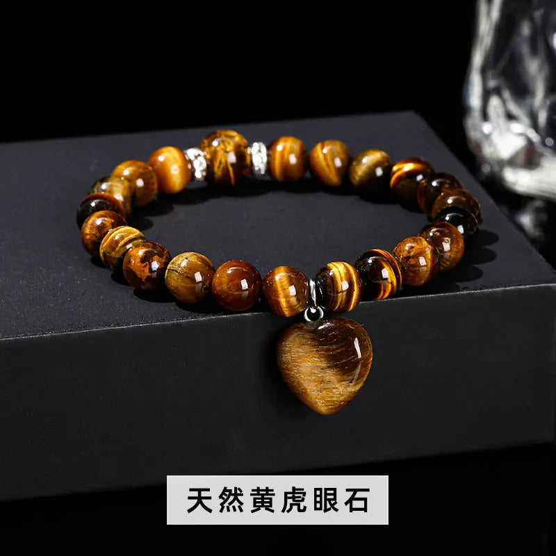 Handmade natural crystal love pendant bracelet with round beads in tiger's eye, aventurine, and white jade on a white background