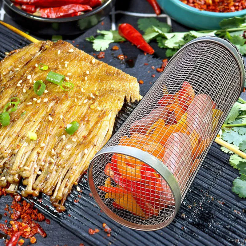 Round stainless steel rolling barbecue grilling basket with mesh sides and a hook, shown with assorted vegetables inside.