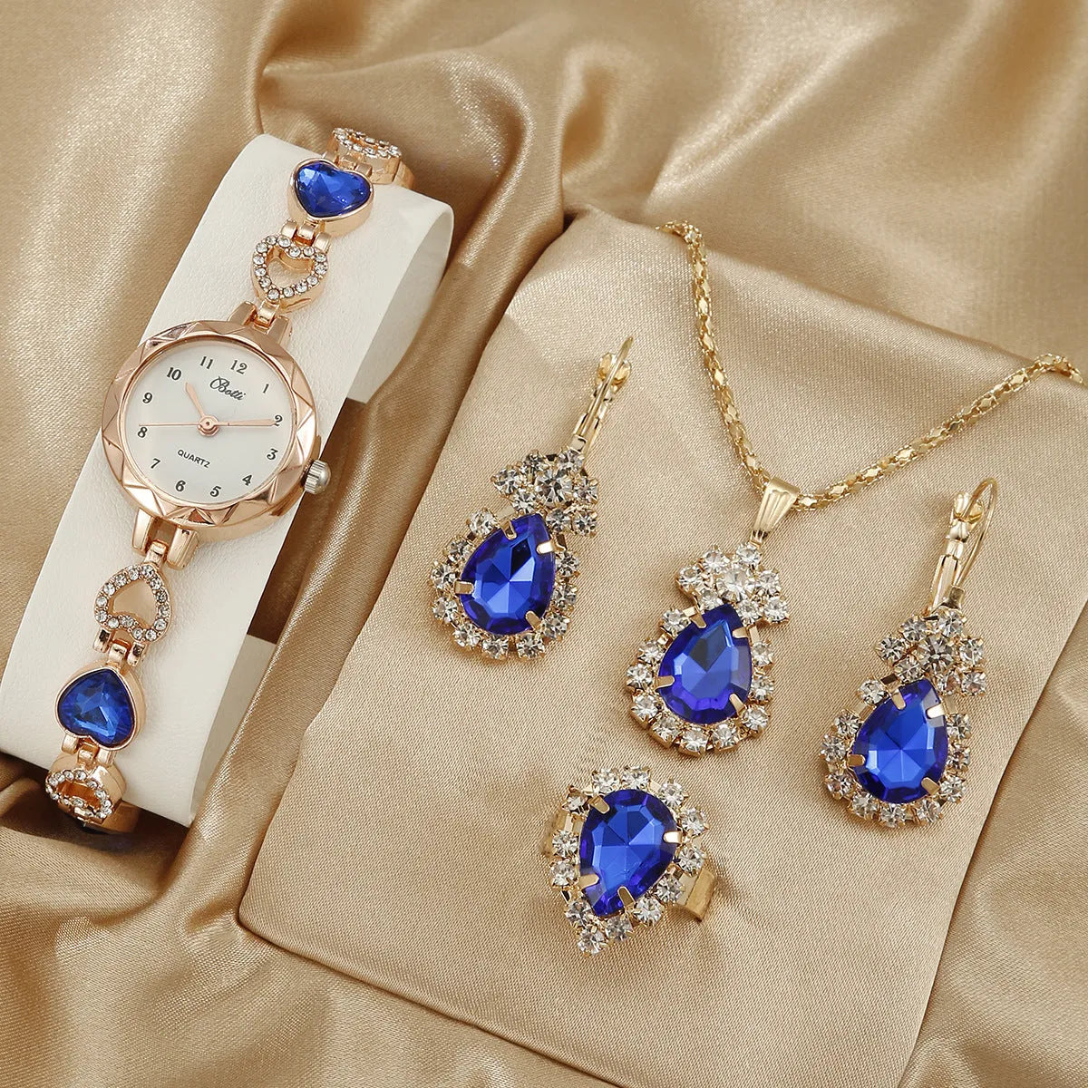 Women's quartz bracelet watch set with earrings necklace ring in pink finish on display