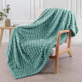 Soft camel-coloured plaid children's blanket folded on a wooden chair.