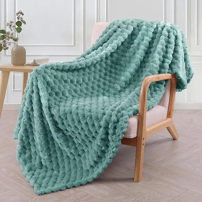 Soft camel-coloured plaid children's blanket folded on a wooden chair.