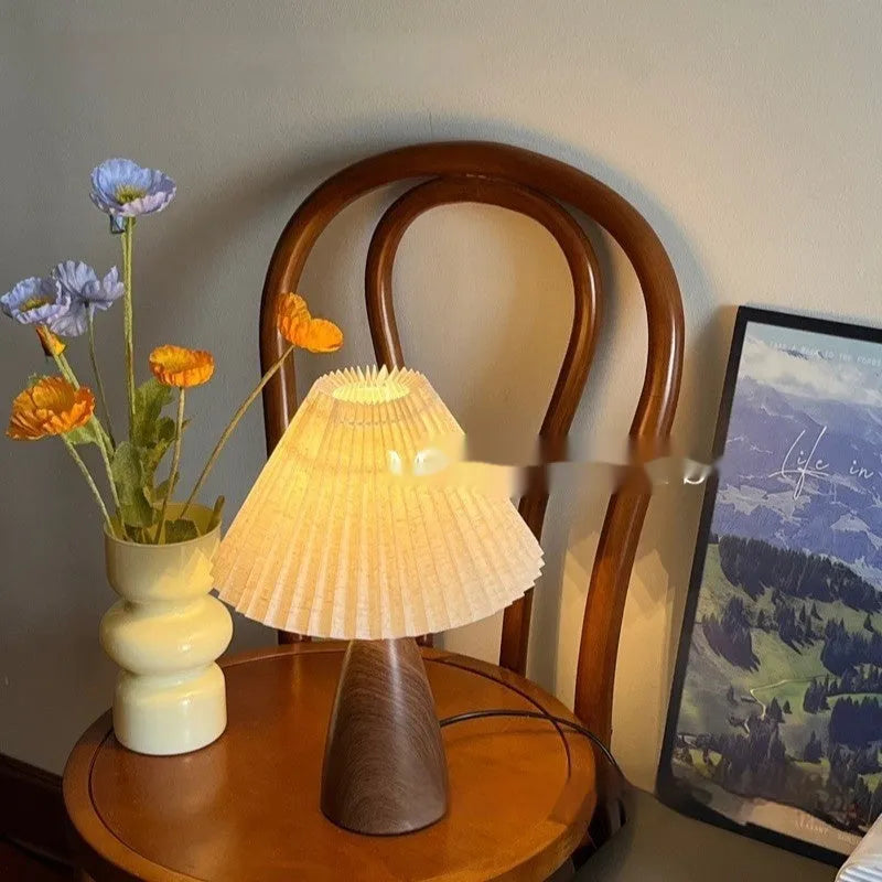 Nordic retro ceramic table lamp with pleated floral shade and remote control on a wooden bedside table.
