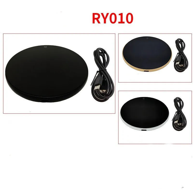 Black USB heating coaster with tempered glass plate on a desk next to a coffee mug