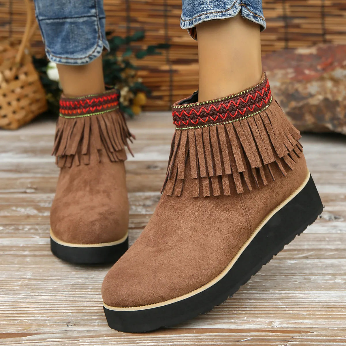 Women's black wedge bootie with suede upper, thick rubber sole, side zipper, and tassel detail.