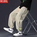 Man wearing loose-fit black trousers with printed stitching detail and a banded ankle cuff.