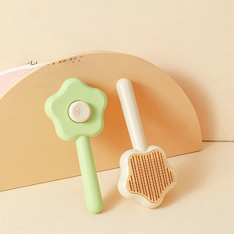 Green and yellow handled self-cleaning pet grooming comb with stainless steel needle bristles.