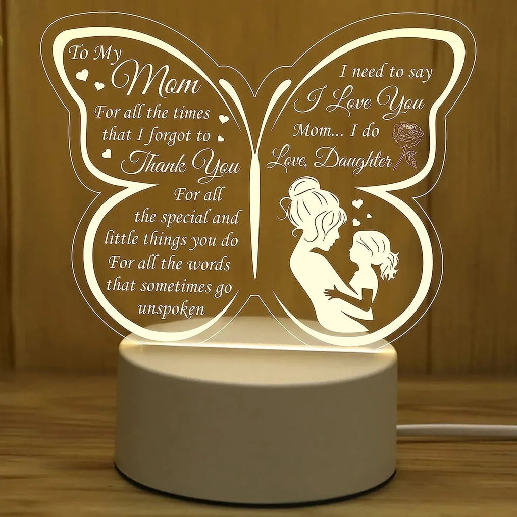 White heart-shaped acrylic table lamp with glowing warm light on a wooden surface.