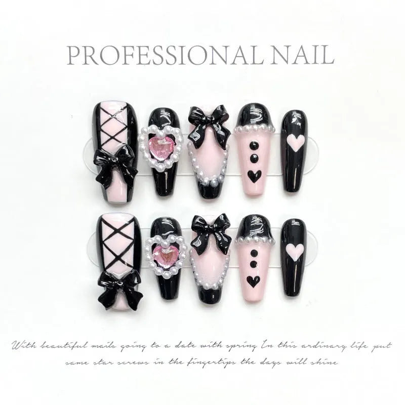 Hand-painted black and pink heart design on detachable plastic manicure nails in cat's eye style.