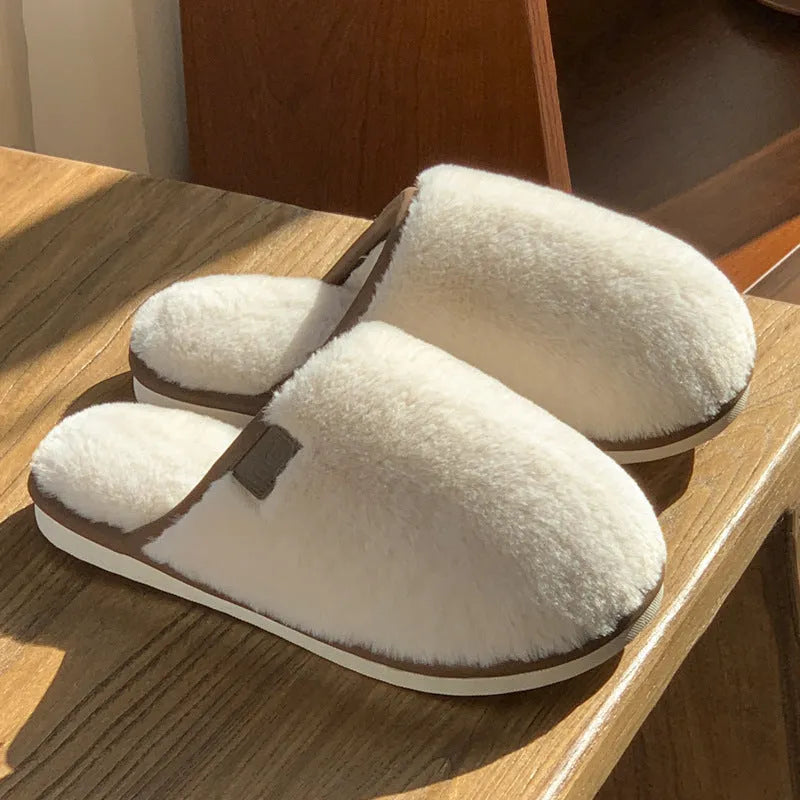 Pair of solid-colour plush house slippers with car stitching detail on the PVC upper.