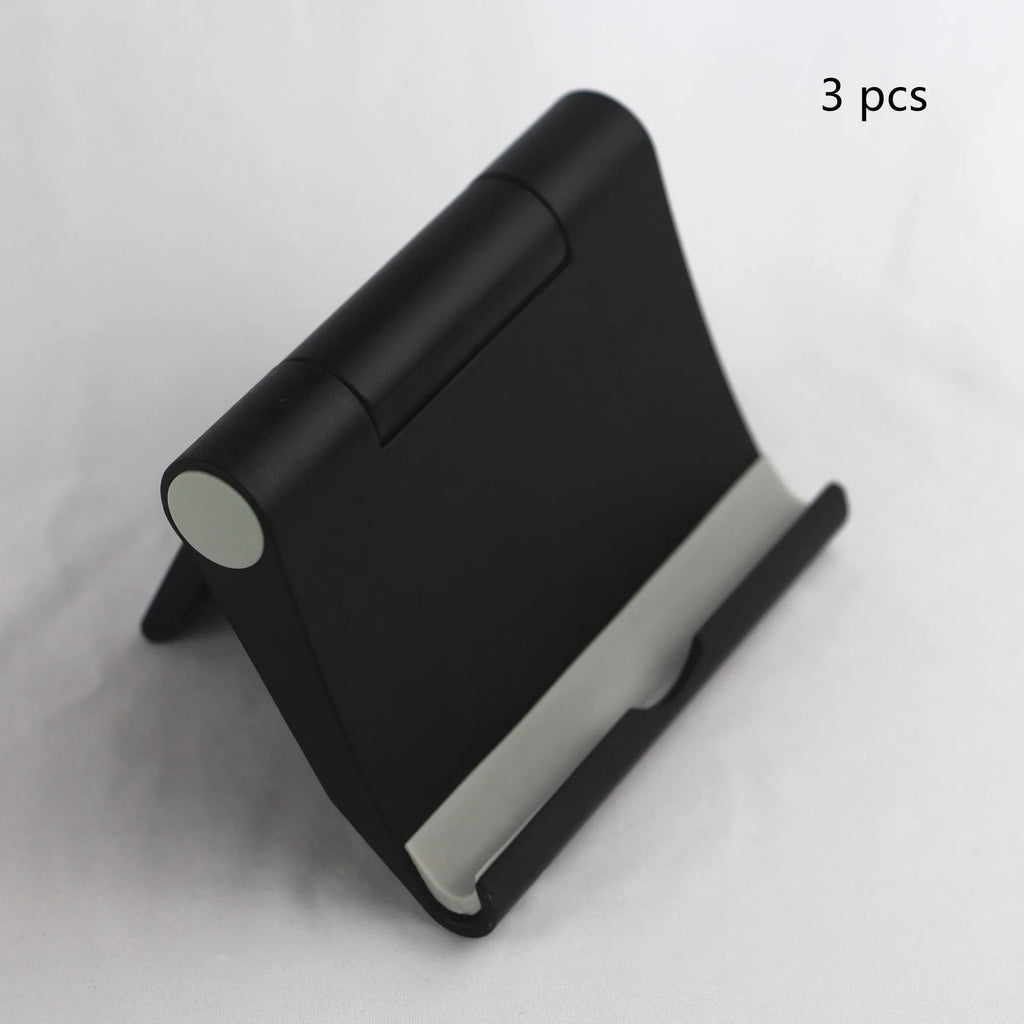 Anti-slip foldable phone holder with silicone pad in black, unfolded on a desk