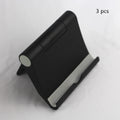 Anti-slip foldable phone holder with silicone pad in black, unfolded on a desk