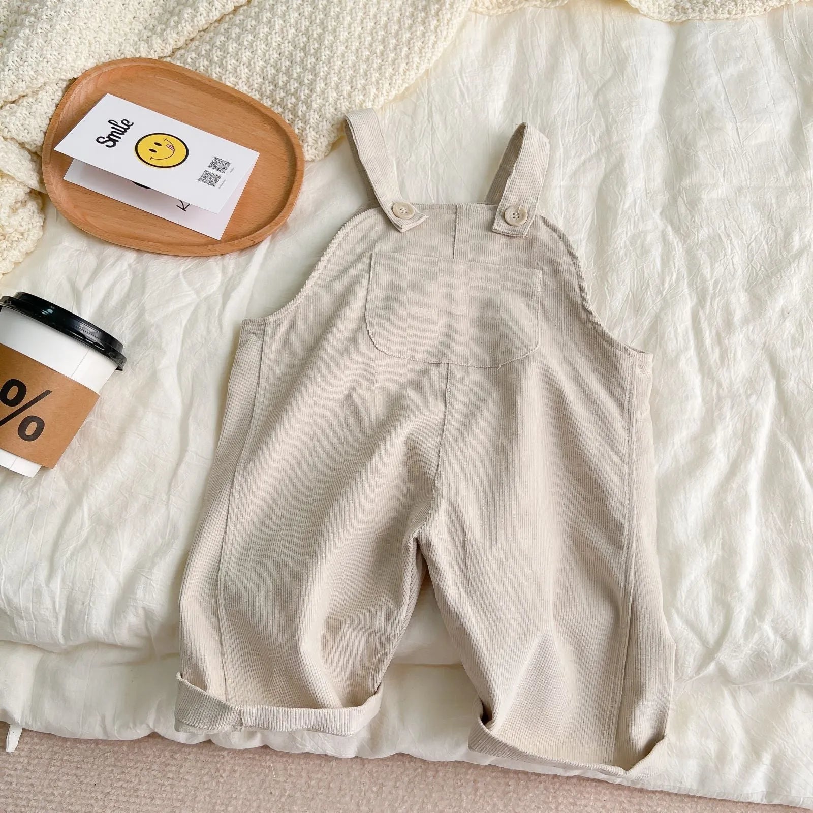 Infant cotton corduroy overalls in creamy white with large front pockets and double-breasted closure