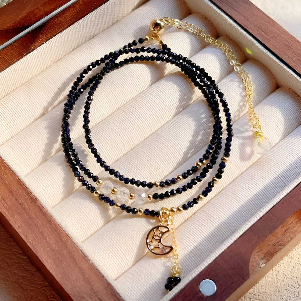 Close-up of a women's multi-layer blue sand bracelet with a three-ring design and gold sand stone cut.