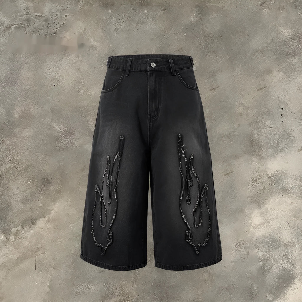 Men's black denim shorts with flame embroidery and a cropped patch on the leg.