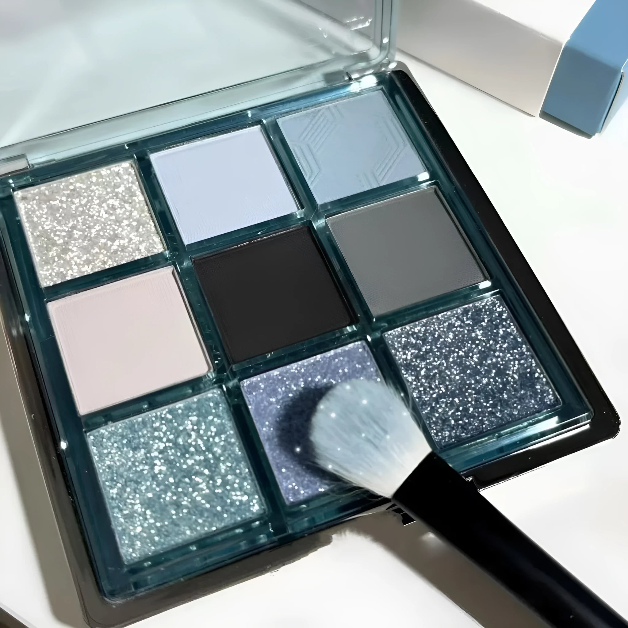 MUGELEEN nine-colour eyeshadow palette showing low saturation blue and earth tones with diamond debris effect