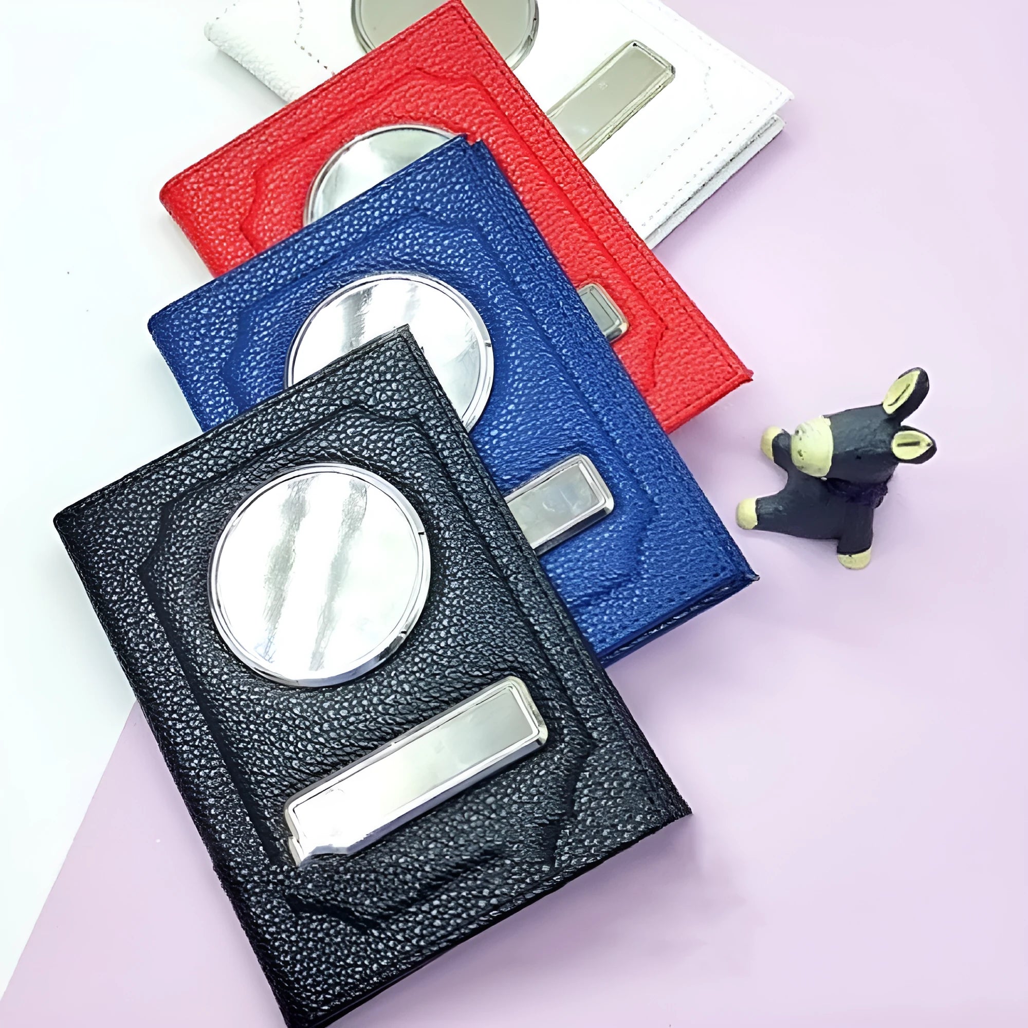 Black synthetic leather passport case with expandable design and aluminum lenses on a plain background