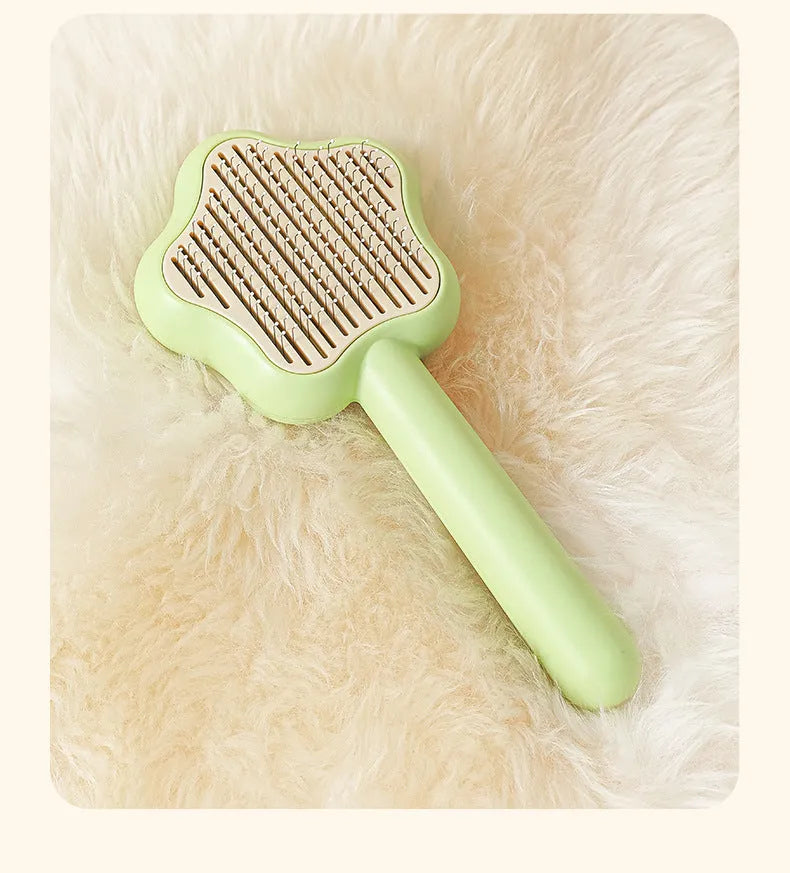 Green and yellow handled self-cleaning pet grooming comb with stainless steel needle bristles.