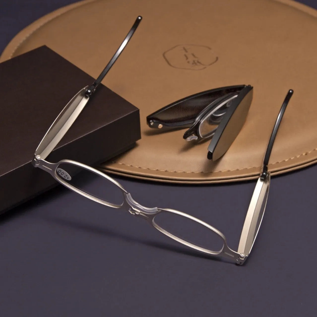 Black folding presbyopic glasses with retro ring-style frame, shown open and collapsed.