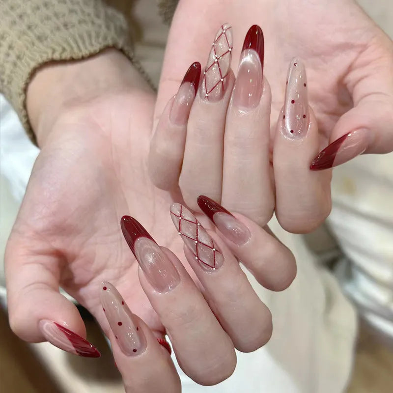 Assortment of sweet girl style false nails in various colours and designs, laid out on a table.