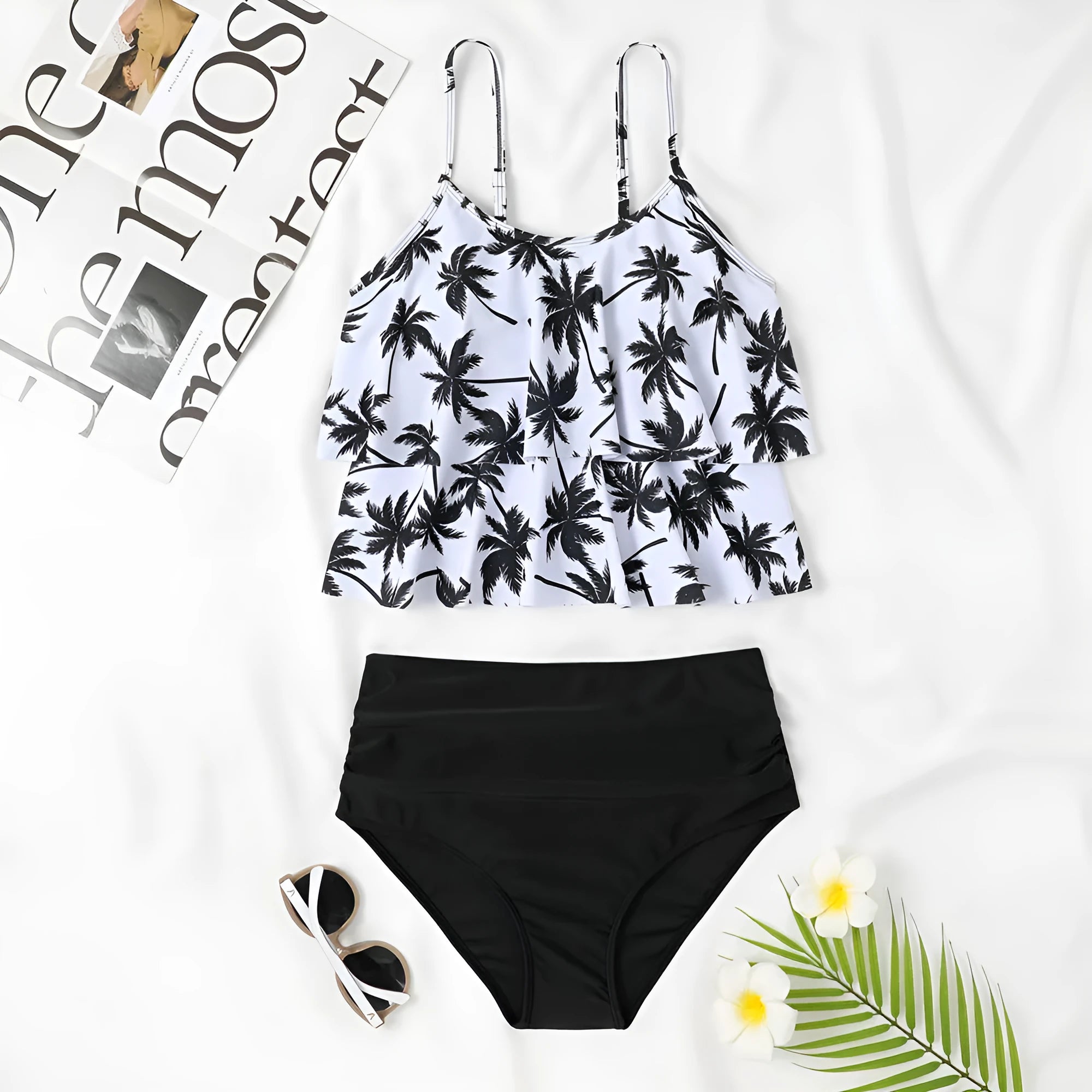 Black high waist swimsuit briefs and sleeveless top with coconut tree print, laid flat.
