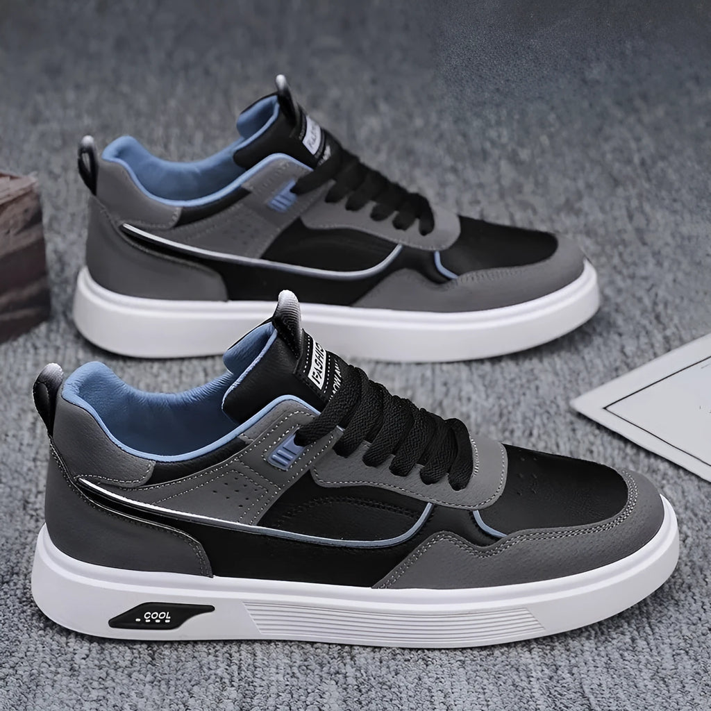 Men's low-top canvas shoes in grey with leather stitching detail on a white background