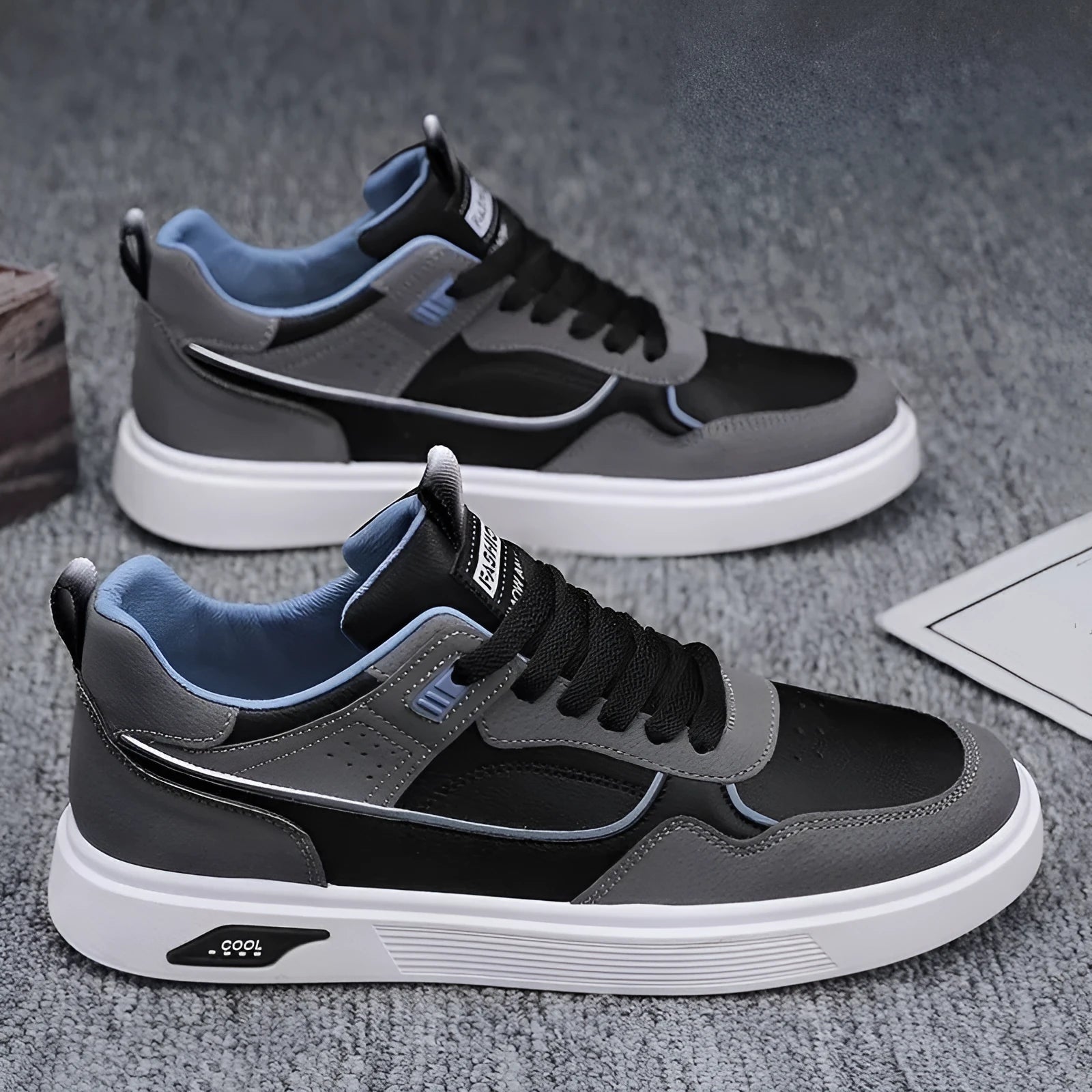 Men's low-top canvas shoes in grey with leather stitching detail on a white background