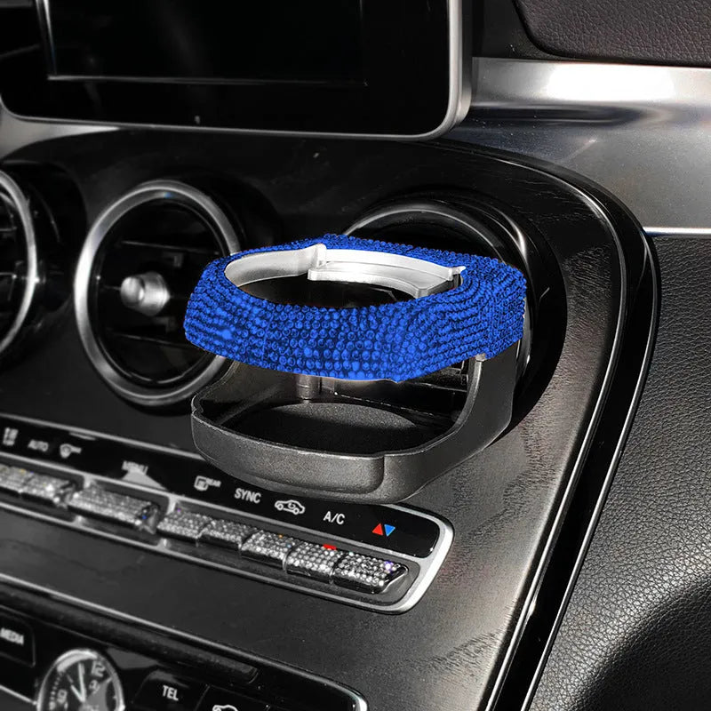 Rhinestone-encrusted white car cup holder bracket mounted on a vehicle air vent.