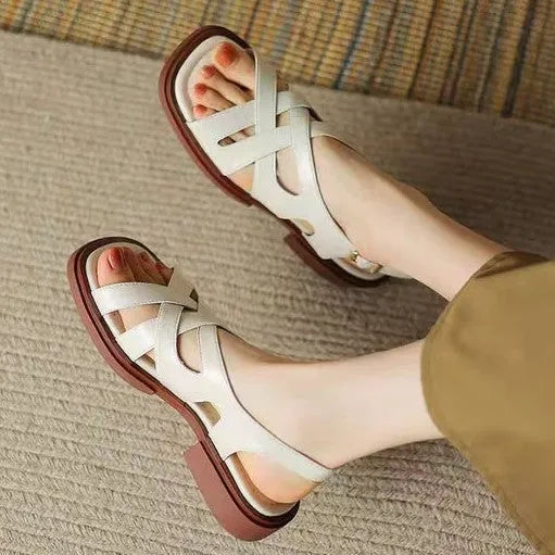 Women's glossy patent leather square toe sandals with a cross-strap design in black.