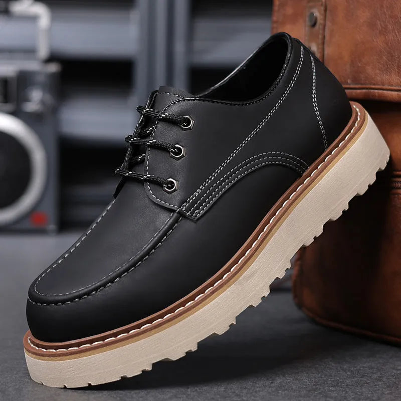 Men's black low-top Martin boots with a round toe and rubber sole on a plain background.