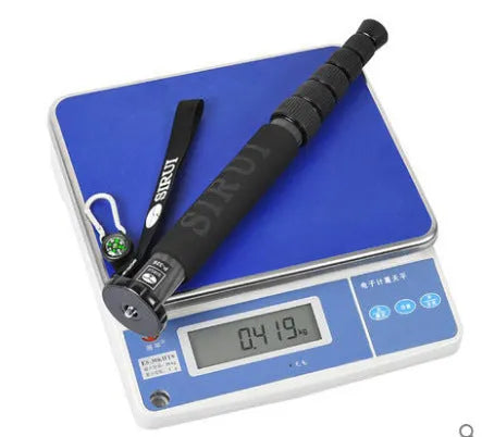 Black carbon fibre telescopic camera monopod fully extended next to an SLR camera