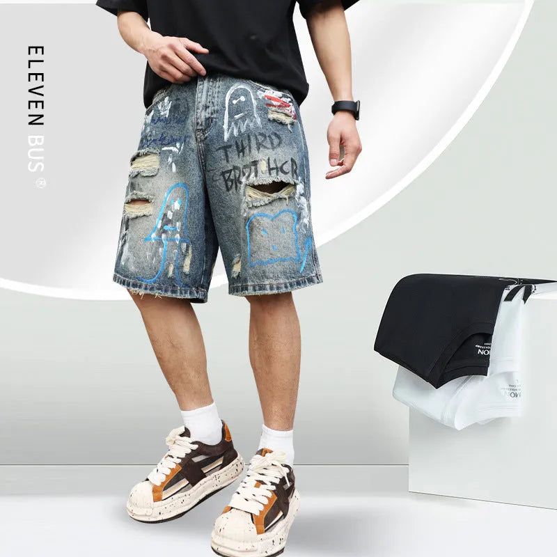 Blue men's ripped denim shorts with graffiti design and straight leg.