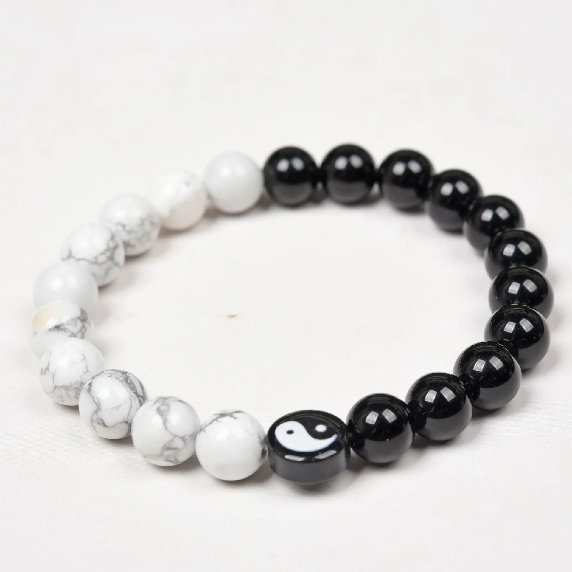 White turquoise and natural obsidian 8mm bead bracelet on a flat surface