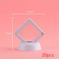 3D floating display case holding a coin suspended between transparent membrane sheets, black frame