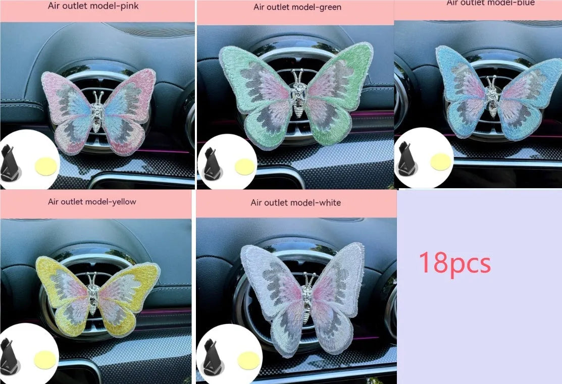 Soft fabric embroidered butterfly car air vent decoration in multiple colour options on a centre console.