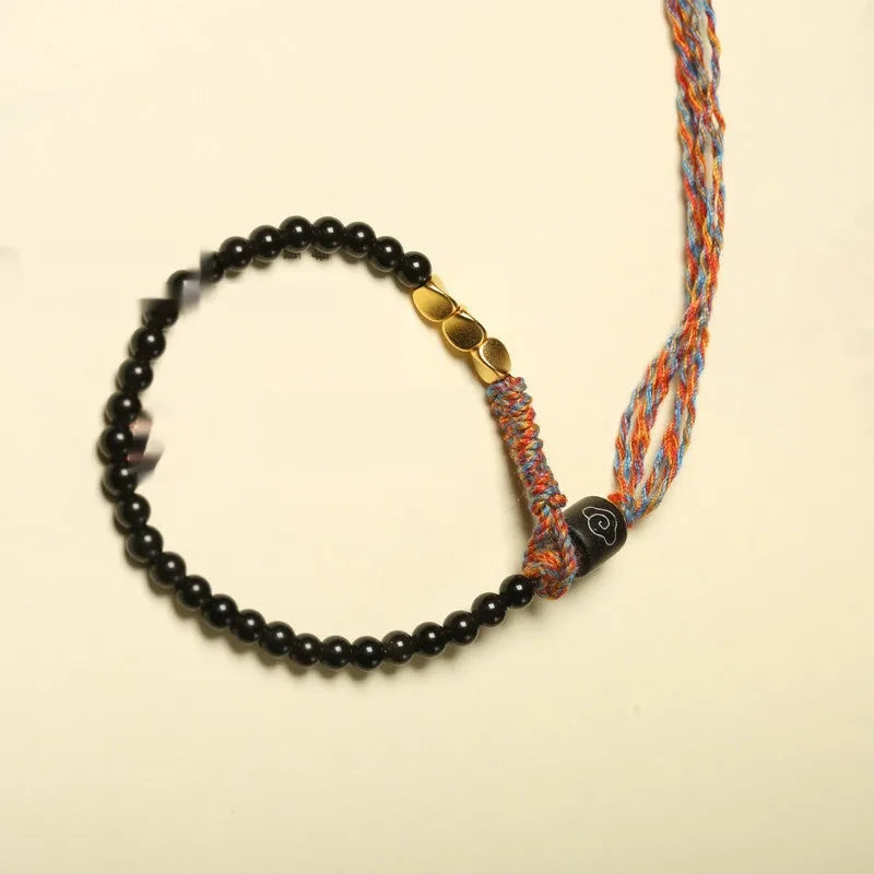 Hand-woven obsidian carrying strap bracelet showing textured surface and adjustable length