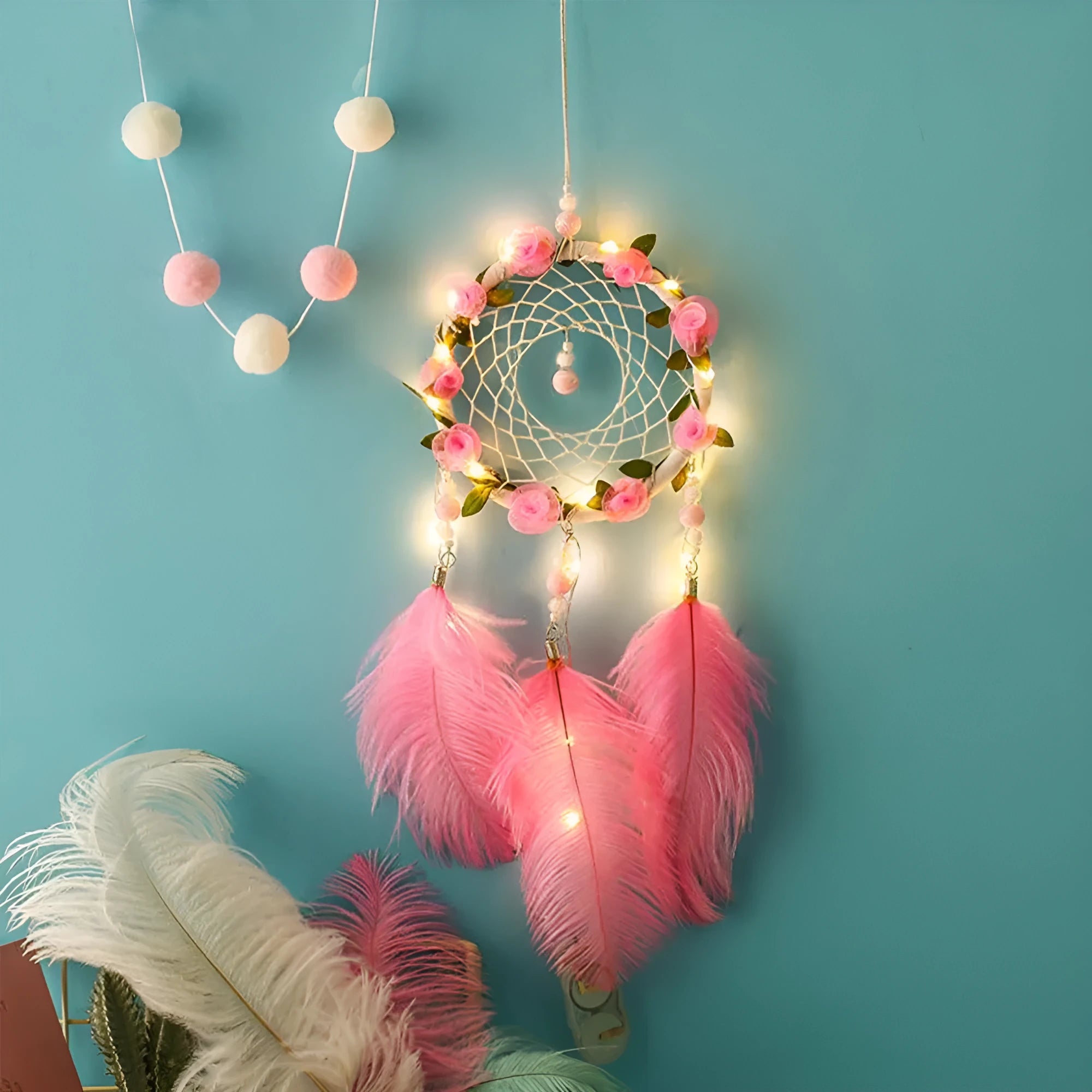 Close-up of a modern pink ostrich feather dreamcatcher wind chime wall ornament.