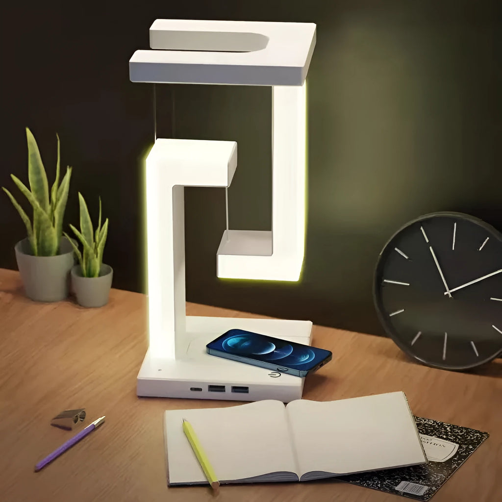 White magnetic suspension table lamp with wireless charging base, floating shade, and foldable bracket on a desk