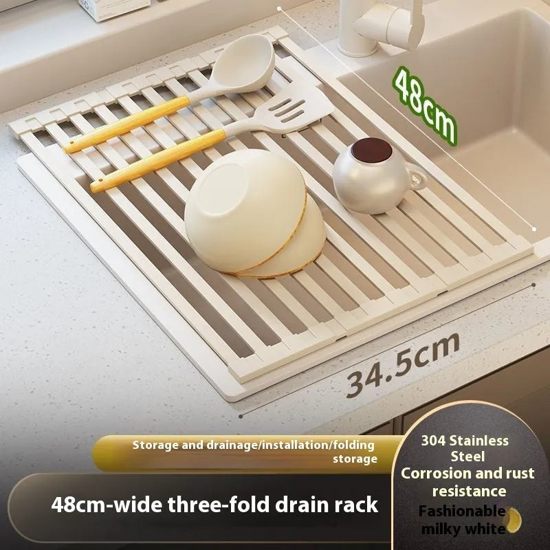Milky White foldable stainless steel kitchen draining rack shown beside a sink, demonstrating its tri-fold mechanism.