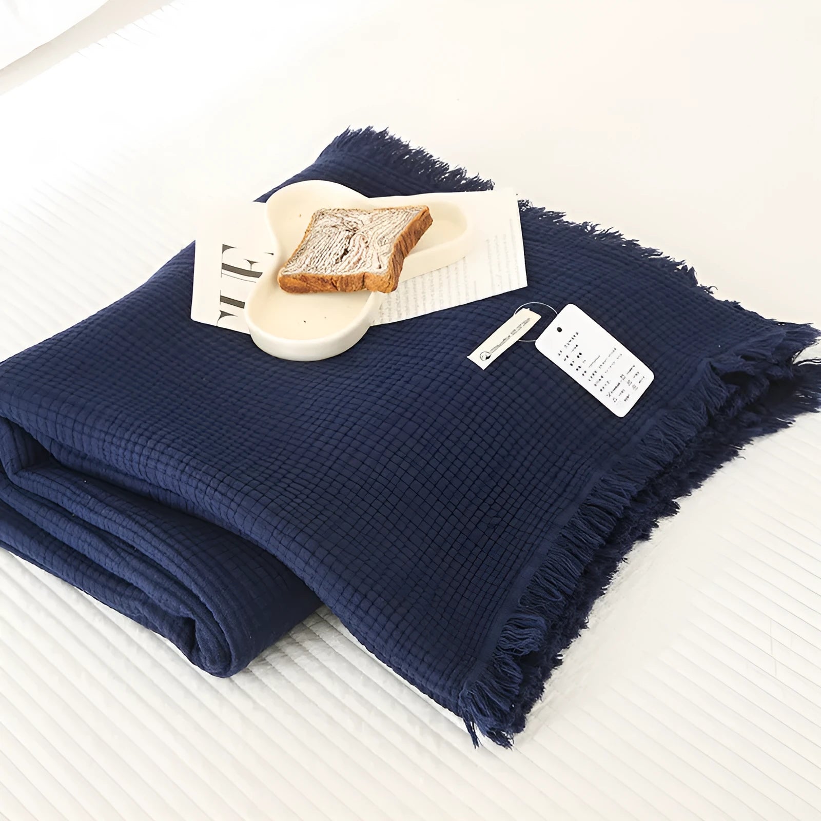 Cotton four-layer gauze blanket with tassel trim in avocado green colour, laid flat.