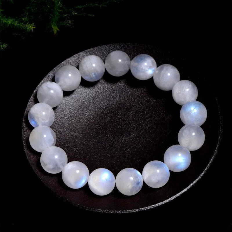 Natural blue moonlight round bead moonstone bracelet on a wrist, showing polished stones.